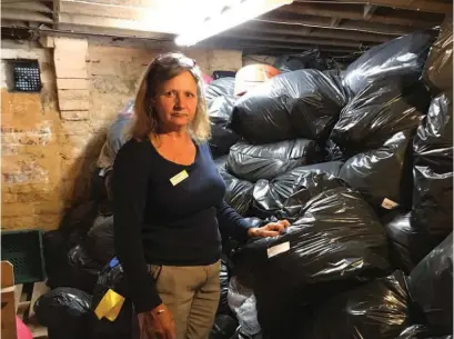  ??  ?? Debbie Stacey with the bags of clothing stored in the basement