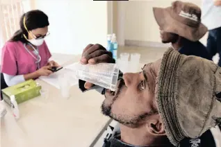  ??  ?? HOMELESS drug addicts receive methadone from a medical staffer at SportparkL­yttelton, where they are being housed during the national lockdown. | African News Agency (ANA)