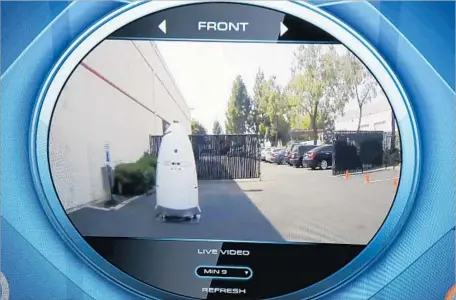  ?? Mark Boster Los Angeles Times ?? THE VIEW from a Knightscop­e security robot’s onboard cameras is shown while it patrols a parking lot in Costa Mesa. The robots can record, stream, send and store video; read license plates; track parked cars; and detect humans in places they’re not...