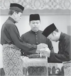  ??  ?? TAKING THE OATH: Tunku Annuar presents the appointmen­t to Mukhriz at Istana Anak Bukit. — Bernama photo