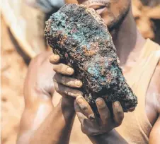  ?? ?? An artisanal miner holds a cobalt stone at the Shabara artisanal mine near Kolwezi.