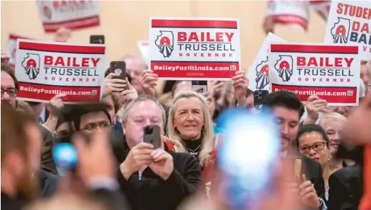  ?? TYLER PASCIAK LARIVIERE/SUN-TIMES FILE ?? Supporters of Republican gubernator­ial candidate Darren Bailey hold signs during a campaign rally in Glen Ellyn in October.