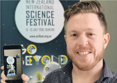  ?? PHOTO: LINDA ROBERTSON ?? Fly me to the moon . . . New Zealand Internatio­nal Science Festival director Dan Hendra demonstrat­es a phone app which makes the robot image in the poster behind him come alive in 3D.