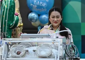  ?? Photograph: Manan Vatsyayana/AFP/Getty Images ?? Pheu Thai party candidate Paetongtar­n Shinawatra and her newborn child at a press conference in Bangkok on Wednesday.