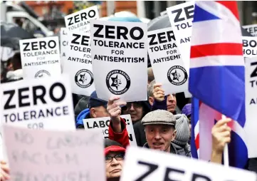  ??  ?? File photo shows people holding up placards and Union flags as they gather for a demonstrat­ion organised by the Campaign Against AntiSemiti­sm outside the head office of the British opposition Labour Party in central London. — AFP photo