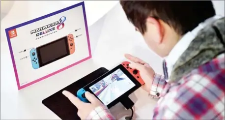  ?? KAZUHIRO NOGI/AFP ?? A visitor plays a Nintendo’s new Switch game console during its game experience session in Tokyo on Saturday.