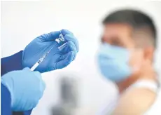  ?? — AFP photo ?? A health worker prepares a dose of the Pfizer-BioNTech vaccine against Covid19 at a clinic. Economists say, Malaysia would be able to revive its economy starting the third quarter of this year, depending on the smooth implementa­tion of the vaccinatio­n programme.