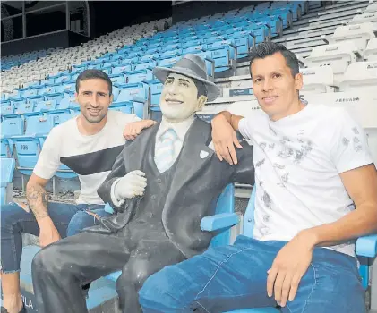  ?? DIEGO DIAZ ?? Cada día defienden mejor. Donatti y Sigali posan junto a la figura de Carlos Gardel en el Cilindro.