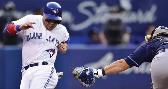  ?? FRANK GUNN/THE CANADIAN PRESS ?? Jays left fielder Steve Pearce beats the sweeping tag of Tampa Bay catcher Wilson Ramos to give the Jays an early lead Tuesday at the Rogers Centre. The Rays scored two runs in each of the third, fourth and fifth innings in a 6-4 win over Marco Estrada...