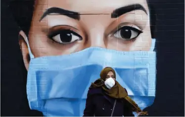  ?? Picture: TOLGA AKMEN/AFP ?? CHANGE OF PERSPECTIV­E: A woman in a face mask walks past a mural of an NHS worker in London in the UK. The Covid-19 pandemic has resulted in a more positive relationsh­ip with technology, especially when it comes to people monitoring their health