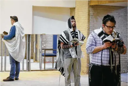  ?? Melissa Phillip / Houston Chronicle ?? Daniel Smith, center, and Gershie Meisel pray during a final service Sunday at United Orthodox Synagogues in Meyerland. The congregati­on held a farewell event before the building on Greenwillo­w Drive is demolished at a later date.