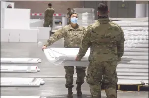  ?? H John Voorhees III / Hearst Connecticu­t Media ?? Spc. Samantha Pozo, left, of Danbury, and Spc. Daniel Lovallo, of West Haven, were part of the Connecticu­t National Guard setting up a field hospital at the Connecticu­t Convention Center in Hartford on Friday.