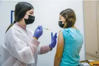  ?? (Yossi Aloni/Flash90) ?? A YOUNG WOMAN receives a COVID-19 vaccine at a Maccabi healthcare center in Modi’in yesterday.