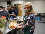  ?? KATHY YOUNG ?? Volunteer Maria Gilosa holds up a packaged Thanksgivi­ng meal for seniors in Hawthorne, N. J., on Nov. 3, 2020. With a fall surge of coronaviru­s infections gripping the U. S., many Americans are forgoing tradition and getting creative with celebratio­ns.