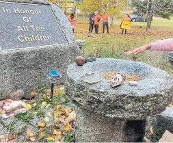  ?? RYAN MOORE PHOTOS FOR THE TORONTO STAR ?? A student from Gaagagekii­zhik School offers tobacco at the Cecilia Jeffrey Indian Residentia­l School memorial in memory of children who went there.