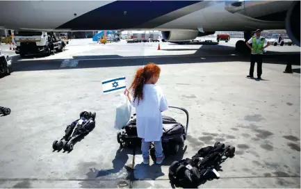  ??  ?? A YOUNG girl waits for new immigrants to disembark at Ben-Gurion Internatio­nal Airport.