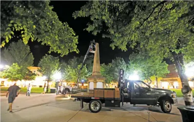  ?? LUIS SÁNCHEZ SATURNO/THE NEW MEXICAN ?? A crew contracted by the state works on the obelisk on the Plaza early Thursday morning.