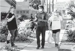  ?? SANDY HUFFAKER ?? Members of the East County Patriots group exchange words with Black Lives Matter demonstrat­ors Saturday in La Mesa.