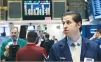  ?? (Brendan McDermid/Reuters) ?? TRADERS WORK on the floor of the New York Stock Exchange yesterday.