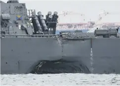  ??  ?? 0 The gaping hole in the side of the USS John S Mccain