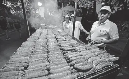  ?? (JAVIER CORTÉZ) ?? En fila. Al caer la tarde, los puestos ya tenían sobre la parrilla las tiras de chorizos.