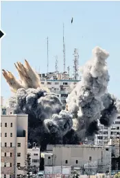  ??  ?? A ball of fire erupts from the Jala Tower (left) as it is destroyed in an Israeli airstrike in Gaza city. The 13-floor tower, which housed Qatar-based Al-Jazeera television and the Associated Press news agency, was completely flattened (below)