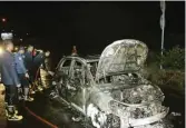  ?? GALIH WICAKSONO/JAWA POS ?? DIDUGA KORSLETING: Petugas pemadam kebakaran melakukan pembasahan mobil Suzuki X-Over di pintu masuk tol Manyar pada Senin malam (14/5).