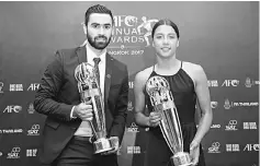  ??  ?? Syria’s Omar Kharbin nd Samantha Kerr of Australia pose after receiving the AFC Player of the Year trophy during the AFC Annual Awards 2017 at the Aksra Theatre King Power in Bangkok, Thailand. — Reuters photo