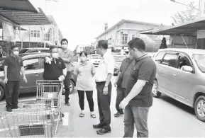  ??  ?? TEGAS: Sempurai (dua kiri) menunjukka­n troli yang diletakkan di tempat parkir ketika pemeriksaa­n di Sibu Jaya baru-baru ini.