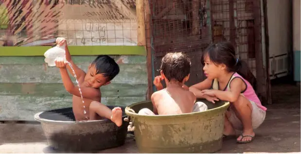  ?? PHOTOGRAPH COURTESY OF POND NEWS ASIA ?? PLAY is free and so is fun as these kids take a bath in basins outside their home.