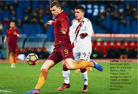  ?? — Reuters ?? Lethal: AS Roma’s Edin Dzeko (left) goes for a shot as Torino’s Silva Falque closes in during the Serie A match at Stadio Olimpico in Rome on Sunday.