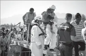  ?? PEPE MARIN / REUTERS ?? Spanish rescue officials carry babies, part of a group intercepte­d aboard dinghies off the coast in the Mediterran­ean Sea, upon arrival at the port of Motril, Spain, on Tuesday.