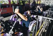  ??  ?? Vallejo firefighte­rs Stephen Kay and Brett Bullock, right, take selfies as they prepare to ride The Joker at Six Flags Discovery Kingdom.