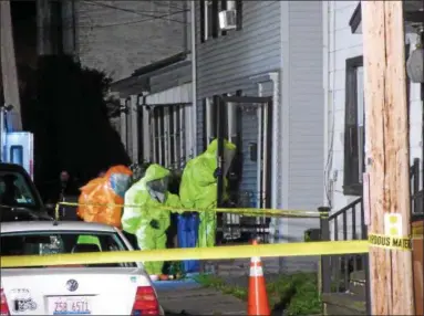  ?? JOHN BECHTOLD PHOTO ?? An emergency response team wearing hazmat suits enters the house at 44 St. James St. on Sunday.