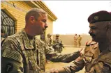  ?? SUSANNAH GEORGE/THE ASSOCIATED PRESS ?? U.S. Army Lt. Col. Brandon Payne, left, meets last month with his Iraqi counterpar­t at a complex in Qaim.