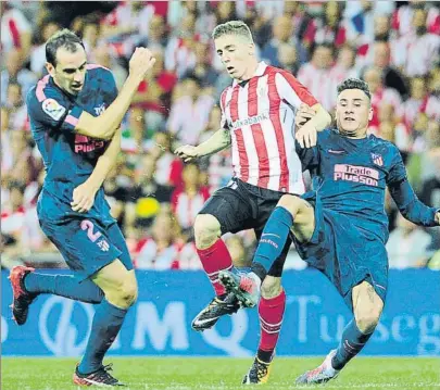  ?? FOTO: JUAN ECHEVERRÍA ?? Muniain intenta avanzar entre Godín y Giménez en el choque de la pasada semana en San Mamés frente al Atlético