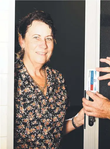  ?? Picture: ALIX SWEENEY ?? ABOVE: Scenes of Crime Unit officer Senior Constable Vincent Prasser has created a new anti-crime prevention initiative with Think, Stop, Lock stickers. He is pictured putting one of the reminder stickers on the door of Mary Hilliard’s home.