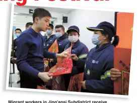  ??  ?? Migrant workers in Jing’ansi Subdistric­t receive gift packages. — Jiang Xiaowei