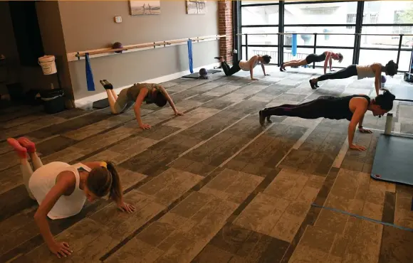  ?? Photos by Kathryn Scott, Special to The Denver Post ?? Instructor Jenn Gilliam, center right, leads this Barre Express class on June 8 at Barre Forte in Denver that normally would include about 17 participan­ts, but is limited to fewer people in order to provide safe social distancing in response to the coronaviru­s pandemic.