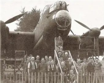  ??  ?? Pictured in Lancaster during WW2 this Lancaster bomber was taken by lorry and assembled by Woodford workers for a special ceremony. They are pictured with, far left in shirt sleeves, legendary works manager ‘Cock’ Bailey