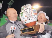  ??  ?? Jeff Siembieda, executive director of the Gildan New Mexico Bowl, left, hands the winner’s trophy to Marshall coach Doc Holliday.