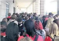  ?? SNAPCHAT ?? In a photo posted on Snapchat, a crowd of students at Boca Raton High School huddle under a covered outside hallway on Monday.