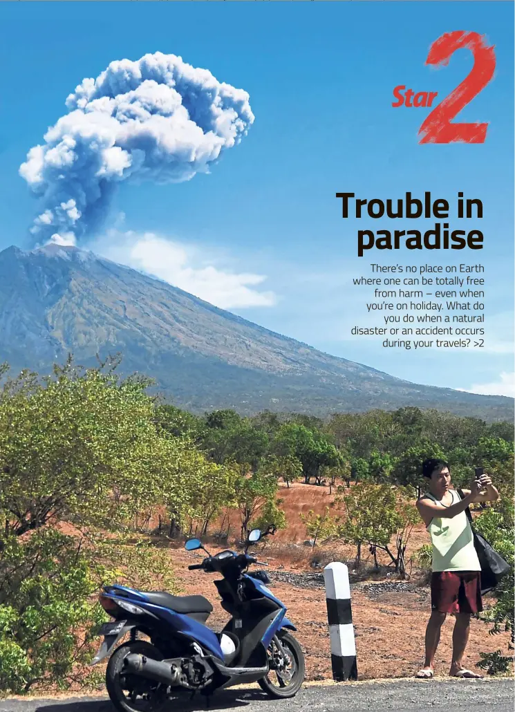  ?? AFP ?? A tourist taking a selfie with his phone as a plume of fresh ash is released by Mount Agung in Bali, Indonesia. —