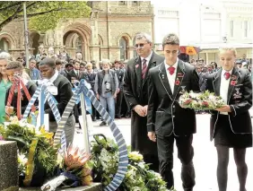  ?? ?? SOLEMN MOMENT: PJ Olivier High School headmaster Joubert Retief, centre, looks on as 2024 head prefects Jaco Slabbert and Marcelle Schoonbee lay a wreath during last month’s Remembranc­e Day parade on Church Square. Schoonbee is the youngest daughter of Ezra and Johlene Schoonbee of Salem, while Jaco Slabbert is the son of Hansie and Karen Slabbert of Kenton-on-Sea.