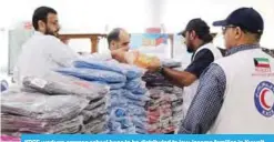  ??  ?? KRCS workers arrange school bags to be distribute­d to low-income families in Kuwait.