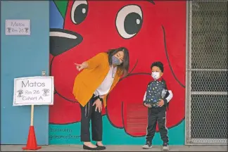  ??  ?? Kindergart­en teacher Lilia Matos and her student Jesus Mendez stand outside their classroom on the first day of in-person learning at Heliotrope Avenue Elementary School.