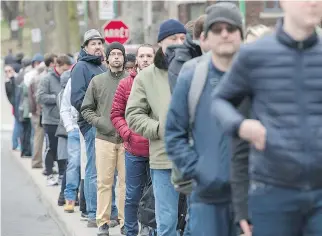  ?? GRAHAM HUGHES/THE CANADIAN PRESS ?? French expats patiently wait in a line that snaked around five blocks to vote in Montreal on Saturday. Emmanuel Macron and Marine Le Pen will face each other in a run-off on May 7.