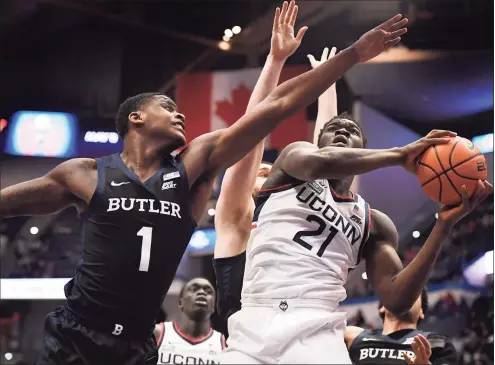  ?? Jessica Hill / Associated Press ?? UConn’s Adama Sanogo (21) shoots as Butler’s Bo Hodges (1) defends during the first half of Tuesday’s game in Hartford.
