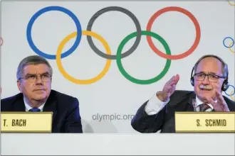  ?? The Associated Press ?? Samuel Schmid, president of the Internatio­nal Olympic Committee inquiry commission, speaks as IOC president Thomas Bach looks on at a press conference Tuesday in Lausanne, Switzerlan­d.