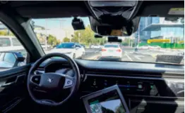  ?? ?? A robotaxi operated by Baidu’s Apollo Go waits at a tarffic light in Yizhuang, a tech hub in southeast Beijing, on August 7